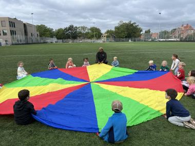 Børn der leger med faldskærm
